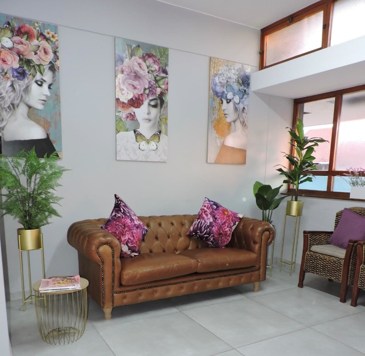 The Moss Dental waiting room with a leather sofa and floral artwork